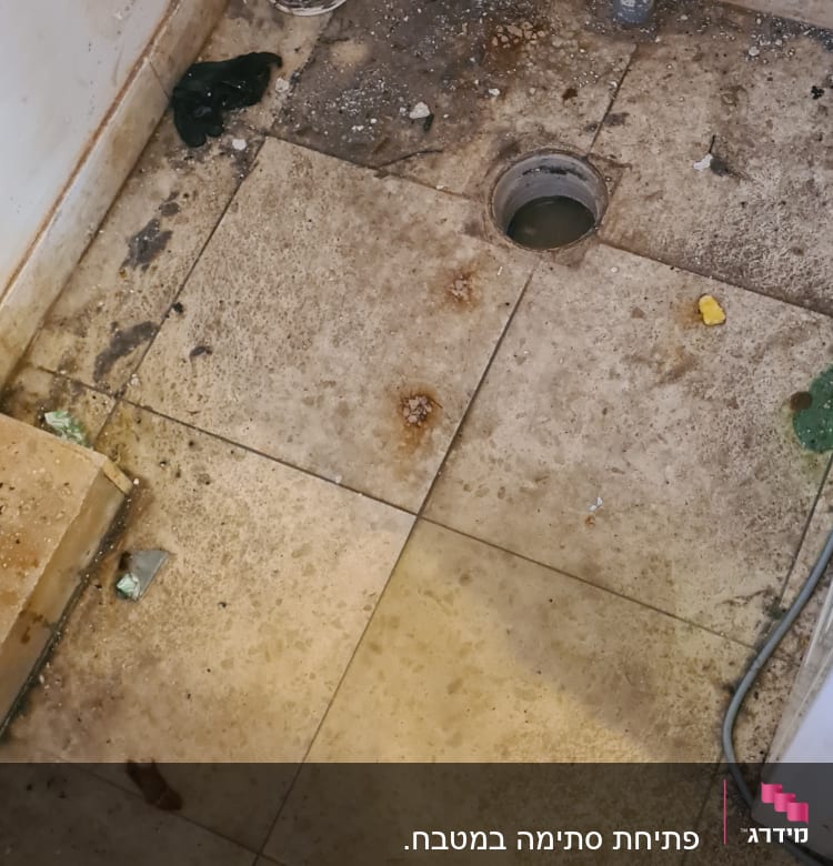 רצפה מלוכלכת עם חור ניקוז וצינור חשוף